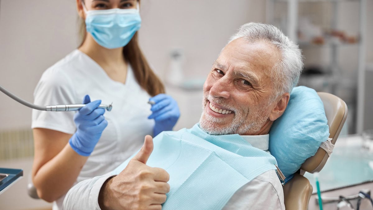 Person in his dentist's office giving thumbs up